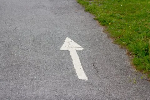 White arrow on the sidewalk. Stock Photos