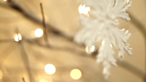 White artificial snowflake decorated with shiny powder on leafless tree Stockbeeldmateriaal 100234534
