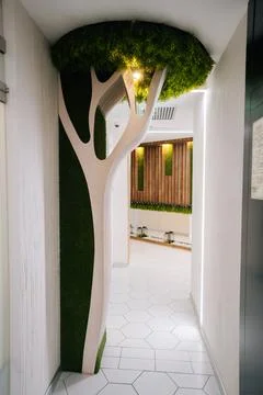 White artificial tree decorated with green moss creating unique atmosphere in Stock Photos