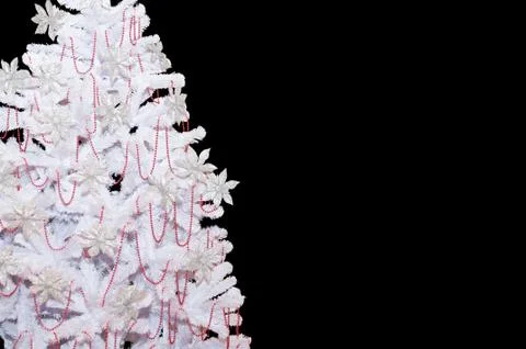 White artificial tree with red ornaments. Isolated on black background Stock Photos