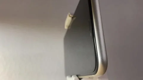 White automatic gimbal stabilizer holding white phone on table Video stock 250469426