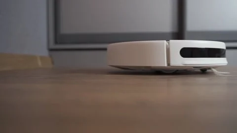 White automatic robot vacuum cleaner with small brushes hoovers Stock Footage 143831719