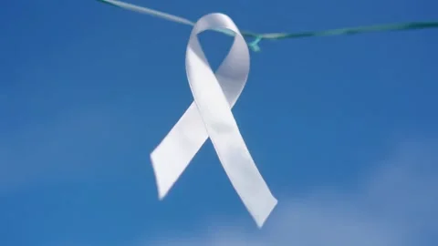 White Awareness Ribbon Blowing in Wind Against Blue Sky 스톡 동영상 338321491