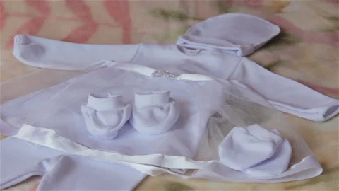 White baby clothes on the bed Vidéo 101945294