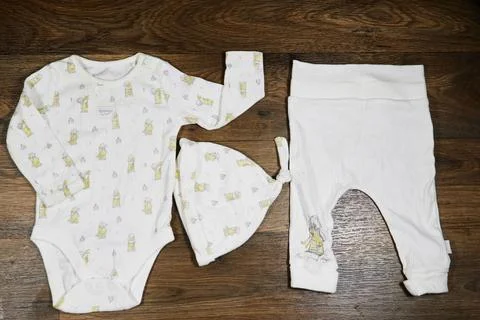 White Baby Clothes Flat Lay With Onesie Hat and Pants on white Background Stock Photos