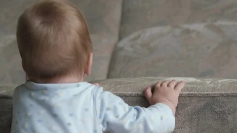 White baby holding a sofa Stock Footage 338173834