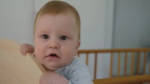 White baby learning to stand in crib Stock Footage 336026679
