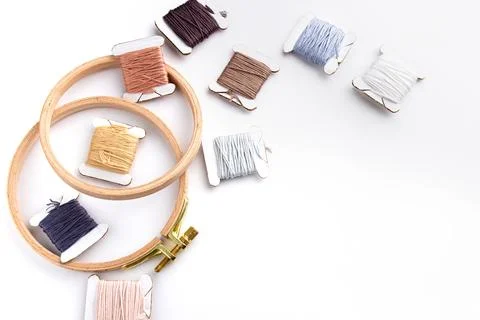 On a white background are cotton threads of different colors wound on bobbins Stock Photos