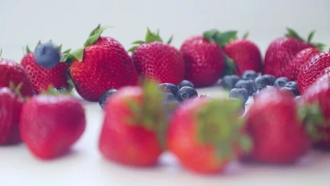 On a white background blueberry fall in strawberries Stock Footage 112104197