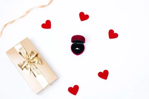 White background with a box with an engagement ring, golden gift box and sm.. Stock Photos