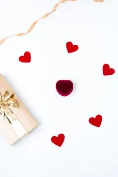White background with a box with an engagement ring, golden gift box and smal Stock Photos