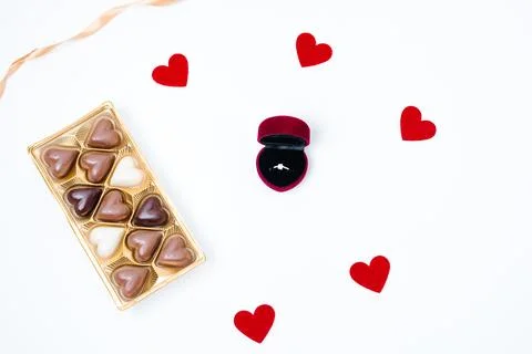 White background with box with an engagement ring, chocolate candies box an.. Stock Photos