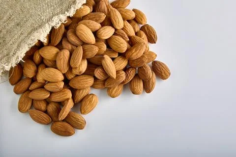 On a white background close-up of raw dried almonds with a bag Foto stock