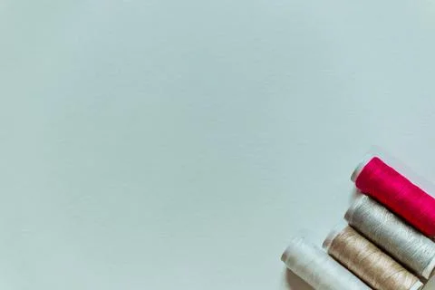 White background with four skeins of thread in the corner. Stock Photos