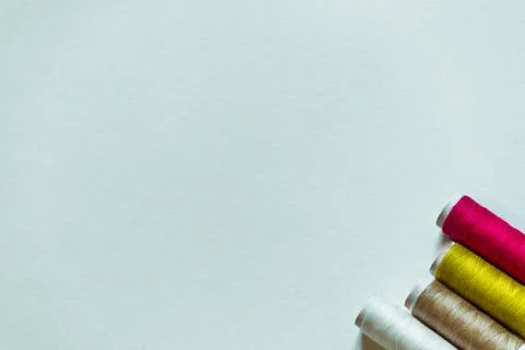 White background with four skeins of thread in the corner. Stock Photos
