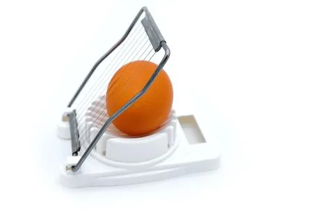 White background, isolate. Egg in the device for cutting. Kitchen device for  Foto stock