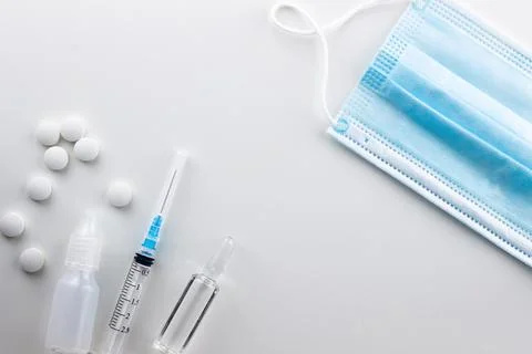 On a white background on the left are round white pills in bulk, two blisters Stock Photos