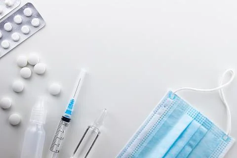 On a white background on the left are round white pills in bulk, two blisters Stock Photos