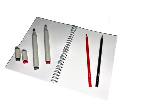 On a white background lies a blank notebook for drawing. It contains two mark Stock Photos