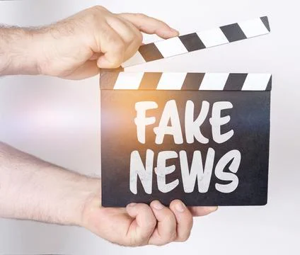 On a white background, a man holds a clapperboard in his hands on which it is Stock Photos