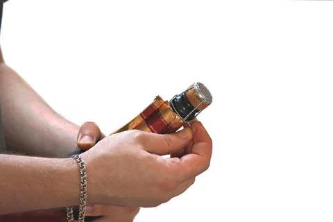 On a white background, a man's hands open a bottle of sparkling wine. Stock-Fotos