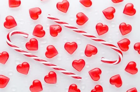 White background with red hearts pattern and candy canes, flat lay Stock Photos