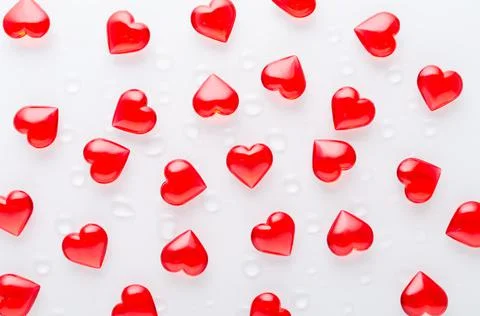 White background with red hearts pattern and water drops, flat lay Stock Photos