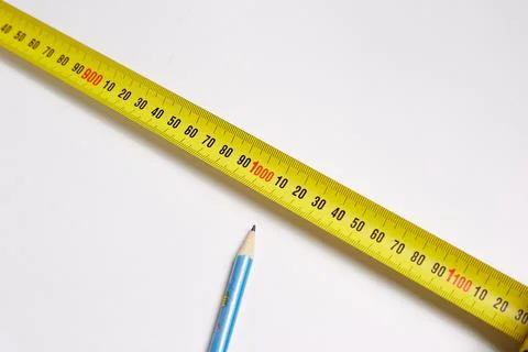 On a white background, a simple pencil and measuring meter, construction repa Stock Photos
