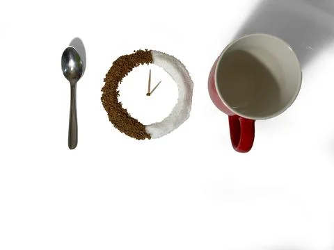 On a white background there is a red cup, next to a clock made of black coffe Stock Photos