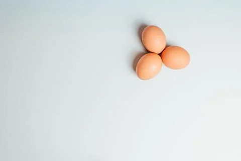 White background with three eggs in a corner Stock Photos