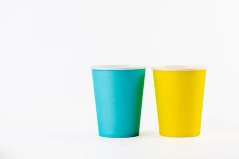 On white background two paper cups for coffee and tea painted in yellow and blue Stock Photos