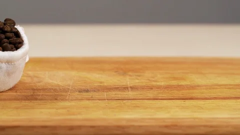 White bag drop from roasted coffee bean slow motion macro spilling arabica table Stock Footage 118979739