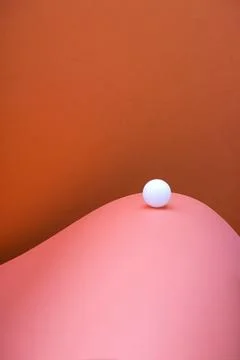 White ball on an abstract background of colored sheets of paper Stock Photos