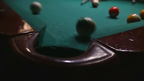 The white ball with the green stripe didn't hit the billiard table in the video Stock Footage 339029210