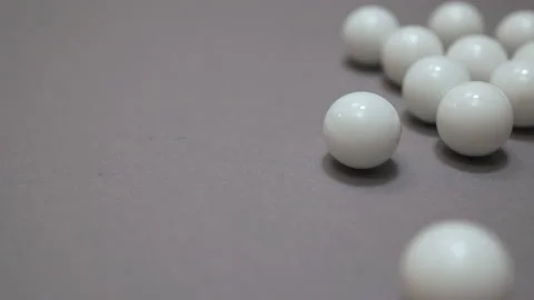 White balls rolling and colliding on the gray suface copy space Stock Footage 147109887