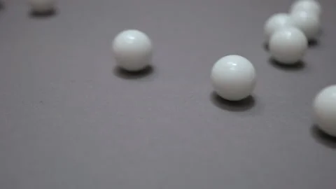 White balls rolling and colliding randomly on the gray suface Stock Footage 147110625
