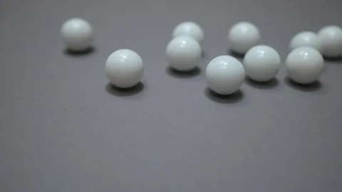 White balls rolling and crushing on the gray suface Stock Footage 147110072