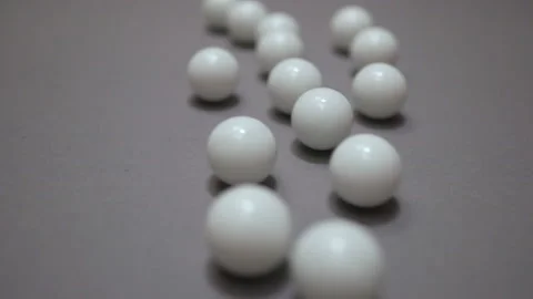 White balls rolling around and colliding randomly on the gray suface Stock Footage 147110217