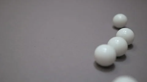 White balls rolling around and colliding chaotic on the gray suface Stock Footage 147110530