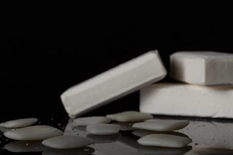 White bars of soap are stacked on top of each other with leftover soap pieces Stock Photos