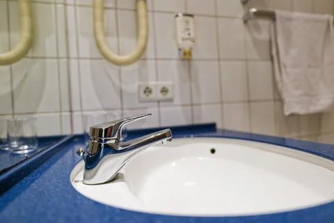 White basin on blue column counter in public wash space Stock Photos