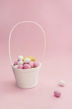 White basket with Easter chocolate multicolored eggs Foto stock