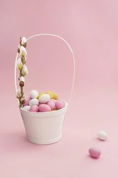 White basket with Easter chocolate multicolored eggs Stock Photos