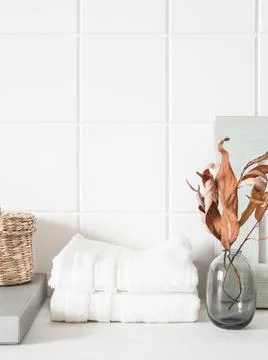 White bath background front view with ceramic vase, white towels and decorati Stock Photos