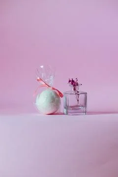 White bath bomb next to a small vase on a pink background. Stock Photos
