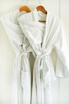 White bathrobe hanging on rack Stock Photos