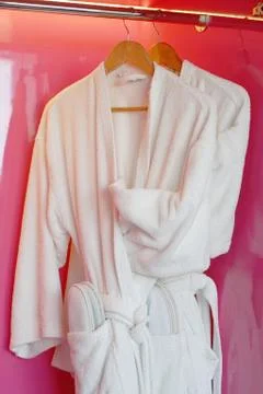 White bathrobe hanging on rack Stock Photos