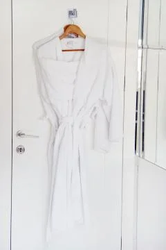 White bathrobe hanging on rack Stock Photos