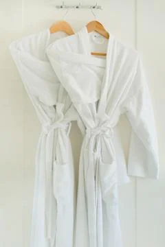 White bathrobe hanging on rack Stock Photos