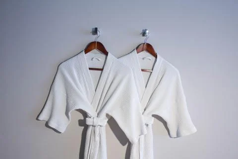 White bathrobe hanging on the wall Stock Photos